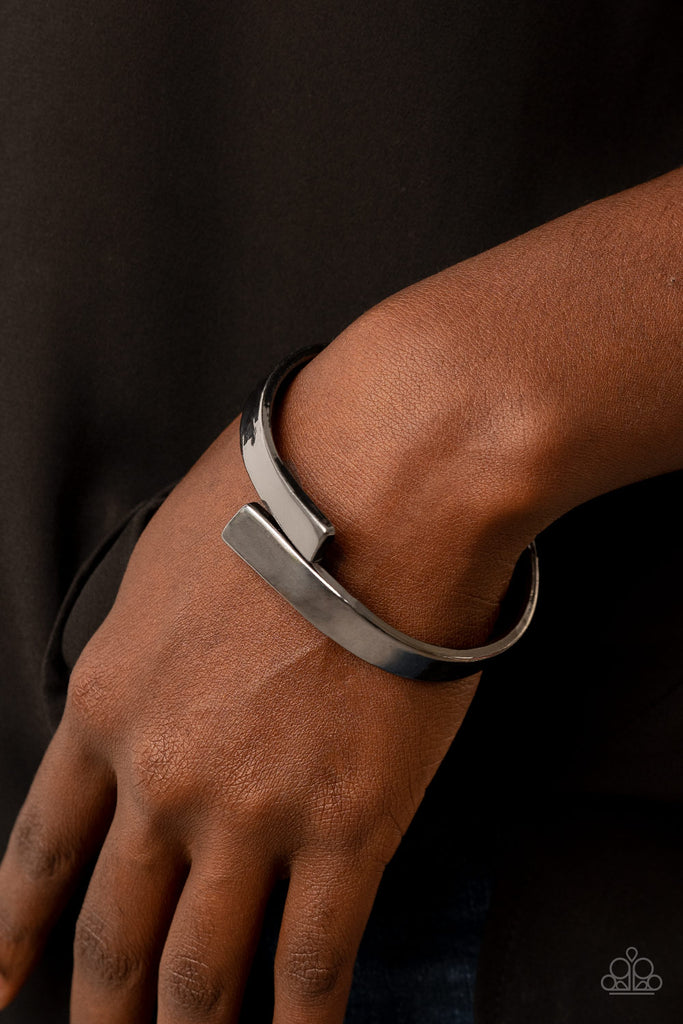 Two oversized gunmetal ribbons delicately overlap across the center of the wrist, creating a stylish and stackable bangle-like cuff. Features a hinged closure.  Sold as one individual bracelet.
