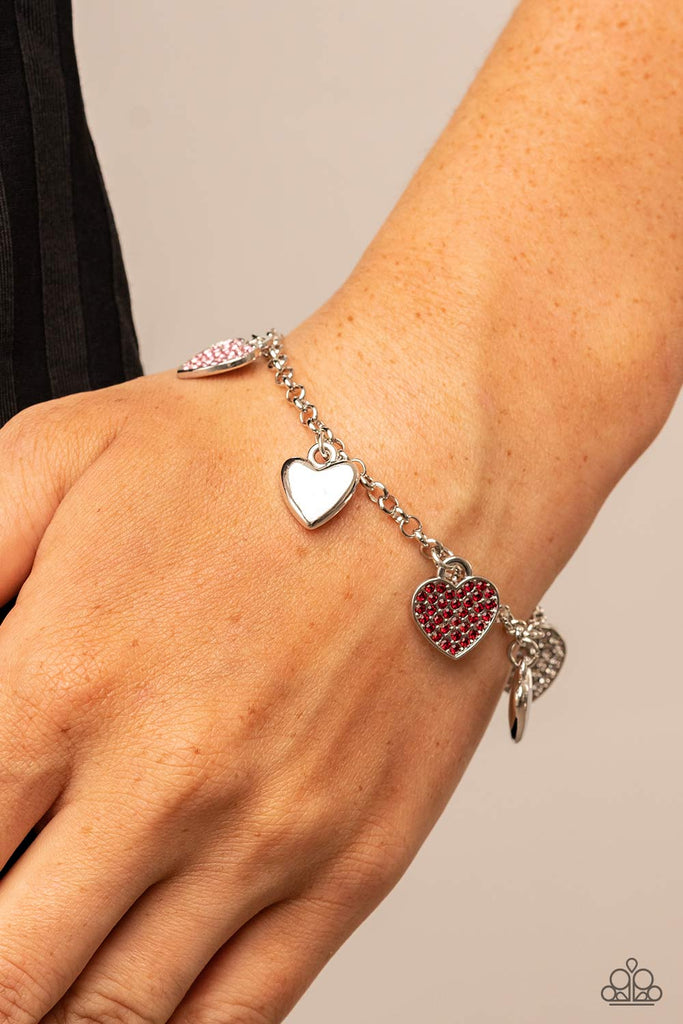Shiny silver heart charms delicately alternate with white, red, and pink rhinestone encrusted heart frames along a silver chain around the wrist, resulting in a flirtatious fringe. Features an adjustable clasp closure.  Sold as one individual bracelet.