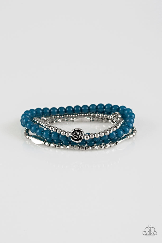 Mismatched silver beads and strands of glassy blue beads are threaded along stretchy bands. Infused with silver accents, dainty rose blossoms adorn the wrist for a seasonal finish.  Sold as one set of four bracelets.