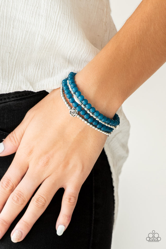 Mismatched silver beads and strands of glassy blue beads are threaded along stretchy bands. Infused with silver accents, dainty rose blossoms adorn the wrist for a seasonal finish.  Sold as one set of four bracelets.