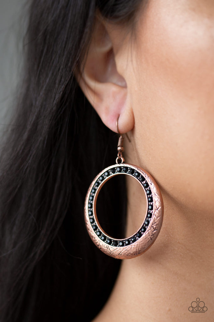 Delicately scratched in antiqued shimmer, a glistening copper hoop is encrusted in a ring of glittery black rhinestones for a refined look. Earring attaches to a standard fishhook fitting.  Sold as one pair of earrings.