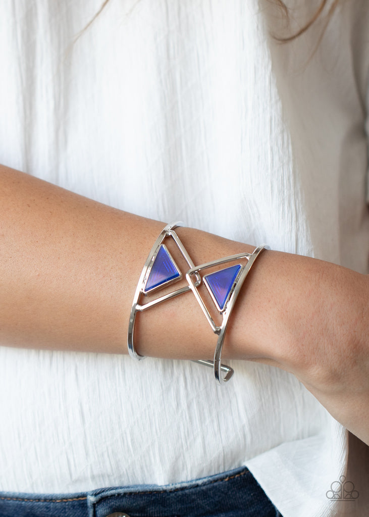 Featuring an oil spill finish, a pair of blue acrylic triangles dot the centers of two overlapping silver triangle frames inside an airy silver cuff for an edgy fashion.  Sold as one individual bracelet.