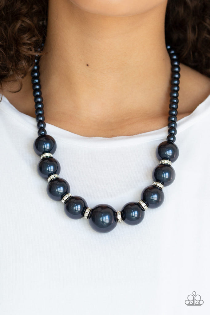 Threaded along an invisible wire, classic navy pearls give way to an alternating collection of over-sized navy blue pearls and white rhinestone encrusted rings below the collar for a timeless sparkle. Features an adjustable clasp closure.  Sold as one individual necklace. Includes one pair of matching earrings.