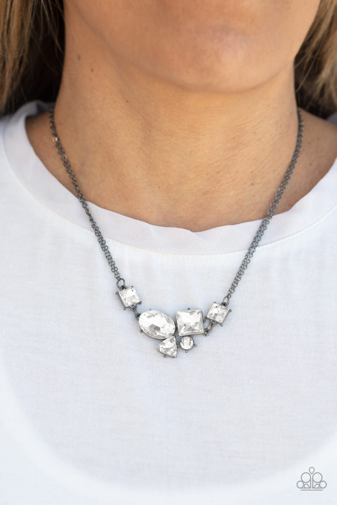 Varying in shape and size, triangular, round, and square cut white rhinestones coalesce into a floating pendant at the bottom of doubled gunmetal chains, creating a stellar shimmer below the collar. Features an adjustable clasp closure.  Sold as one individual necklace. Includes one pair of matching earrings.