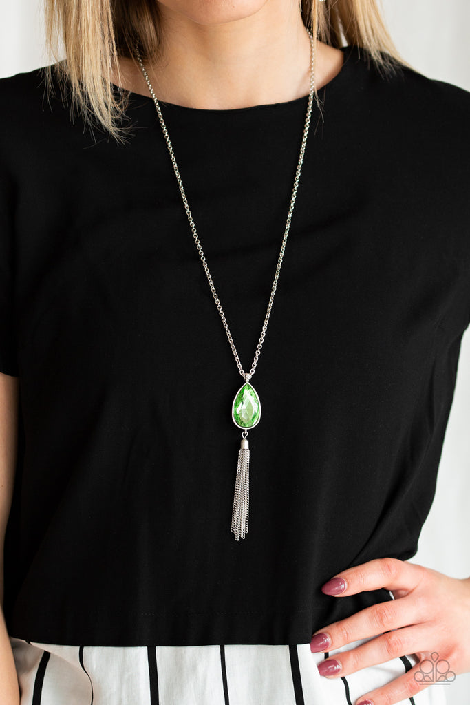 A green teardrop gem swings from the bottom of a lengthened silver chain for a dramatic look. A shimmery silver chain tassel swings from the bottom of the pendant for a glamorous finish. Features an adjustable clasp closure.  Sold as one individual necklace. Includes one pair of matching earrings.