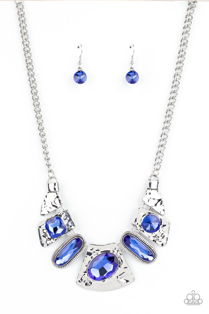 Mismatched French Blue gems adorn the front of hammered silver plates that abstractly connect below the collar, creating an out-of-this-world statement piece. Features an adjustable clasp closure.  Sold as one individual necklace. Includes one pair of matching earrings.
