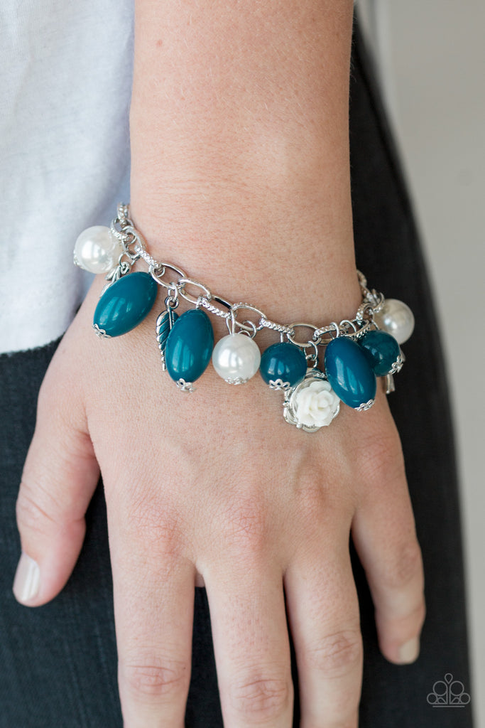 Gorgeous pearls, luminescent blue beading, and a collection of shiny silver charms, including a bird and a feather, dance around the wrist in a whimsical fashion. Features an adjustable clasp closure.  Sold as one individual bracelet.