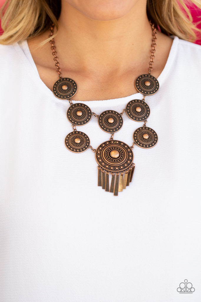 Studded in tactile circular patterns, a collection of antiqued copper disc-like frames connects into a stacked tribal pendant. A larger copper disc is suspended from the bottom, giving way to a fringe of flared copper accents for a noisemaking finish. Features an adjustable clasp closure.  Sold as one individual necklace. Includes one pair of matching earrings.