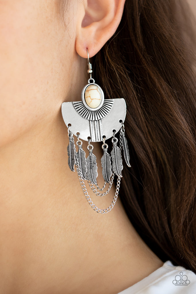 A fringe of antiqued silver feathers and shimmery silver chains dangle from the bottom of a fanning silver frame dotted with a smooth white stone for an earthy finish. Earring attaches to a standard fishhook fitting.  Sold as one pair of earrings.