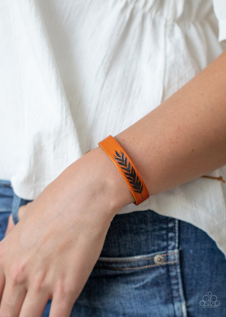 A shiny black feather is delicately painted across the center of a dainty leather band, creating a free-spirited look around the wrist. Features an adjustable sliding knot closure.  Sold as one individual bracelet.
