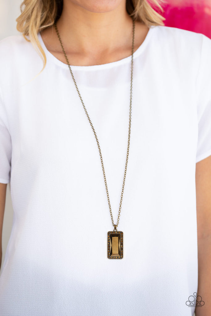The dramatic pendant swings from the bottom of a lengthened brass chain for an edgy look. Features an adjustable clasp closure. Sold as one individual necklace.  Includes one pair of matching earrings.