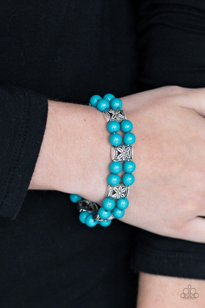 Double rows of vibrant blue beads and floral silver frames are threaded along stretchy bands around the wrist for a whimsical flair.  Sold as one individual bracelet.