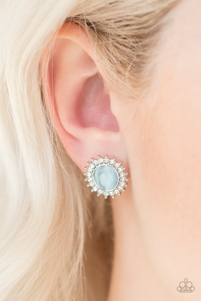 Dazzling white rhinestones spin around a glowing a blue moonstone for a dazzling look. Features a standard post fitting.  Sold as one pair of post earrings.