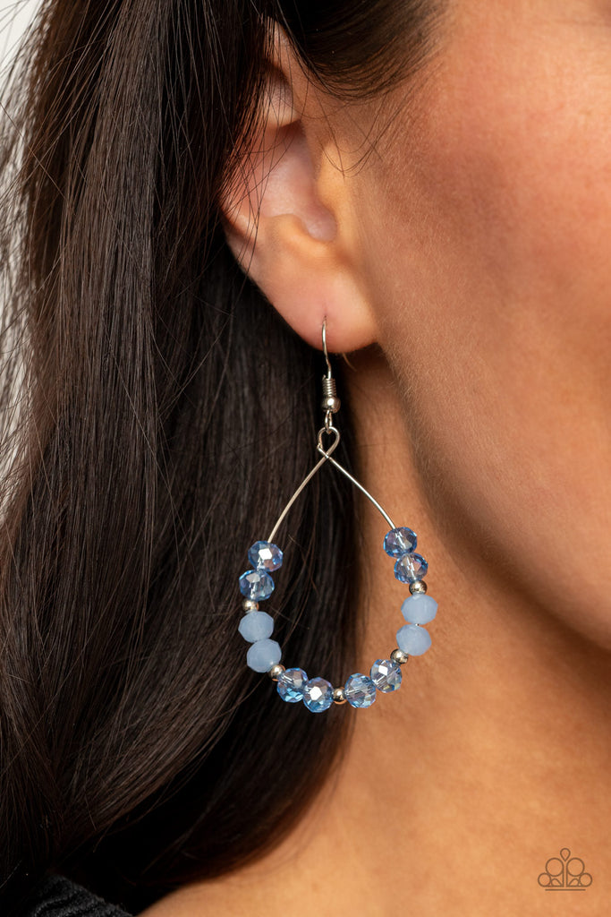 Infused with dainty silver beads, a sparkly collection of glassy and opalescent Cerulean crystal-like beads glide along a dainty silver wire, coalescing into a twinkly teardrop. Earring attaches to a standard fishhook fitting.  Sold as one pair of earrings.