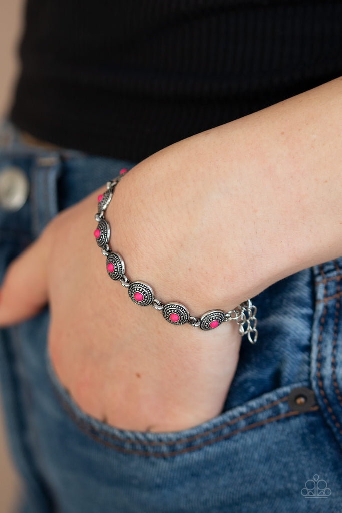 Dotted with dainty pink stone centers, studded silver frames delicately link across the wrist for a seasonal look. Features an adjustable clasp closure.  Sold as one individual bracelet.