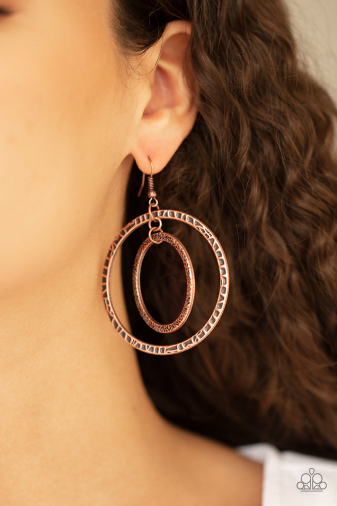 Mismatched copper hoops swing from the ear, creating a collision of metallic texture. Earring attaches to a standard fishhook fitting.  Sold as one pair of earrings.