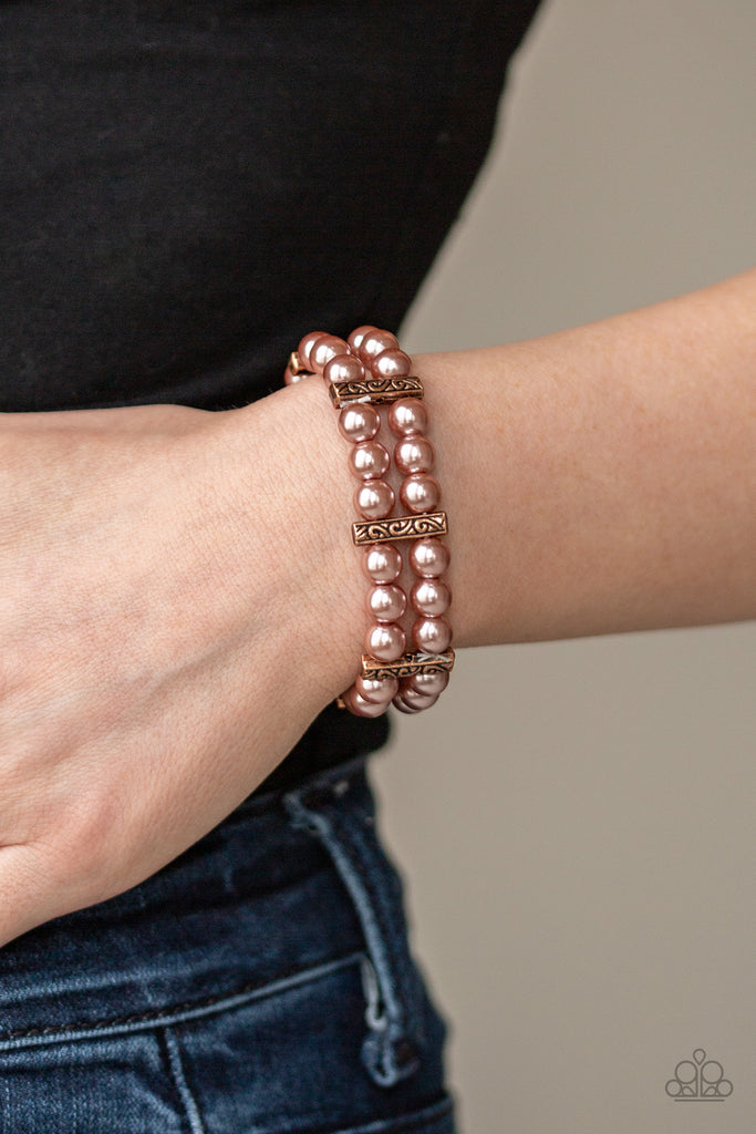 Joined together by decorative copper fittings, pairs of coppery pearls are threaded along stretchy bands around the wrist, coalescing into a timeless bracelet.  Sold as one individual bracelet.