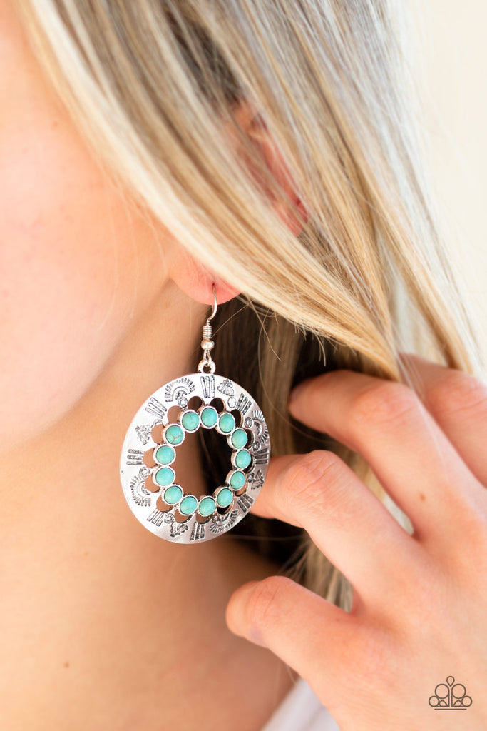 Refreshing blue stones spin around the center of a shimmery silver hoop stamped in tribal inspired patterns for a seasonal look. Earring attaches to a standard fishhook fitting.  Sold as one pair of earrings.