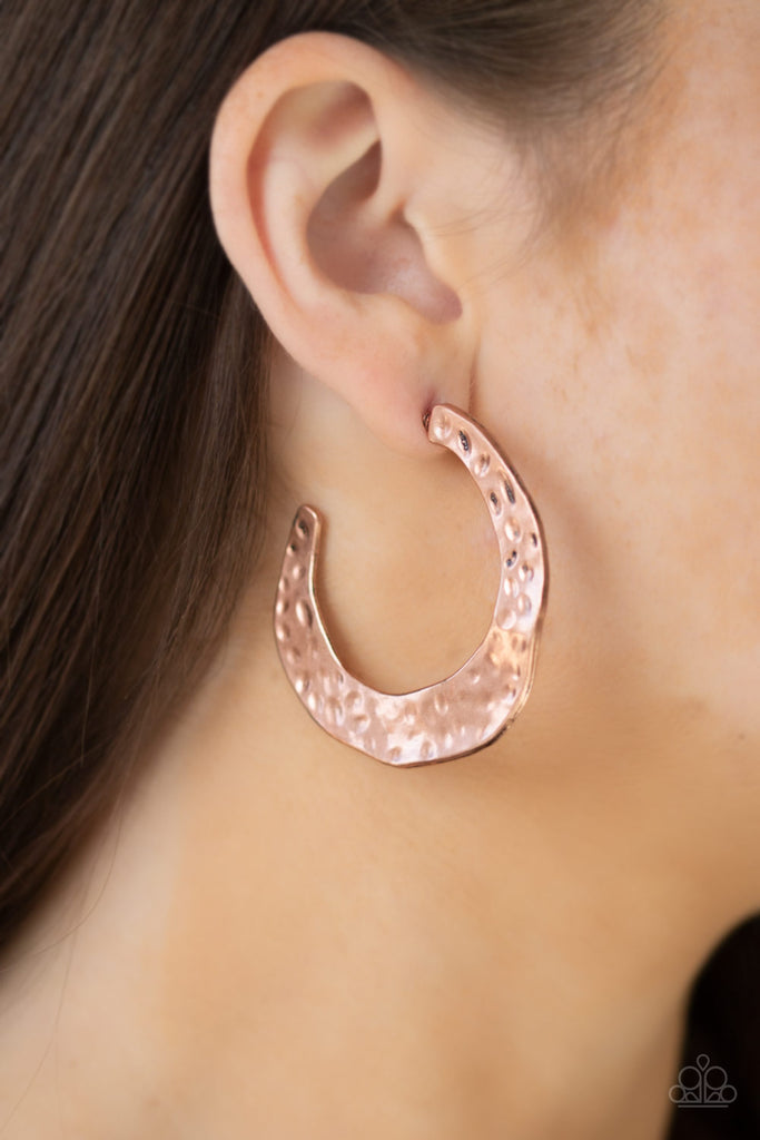 Radiating with hammered detail, an asymmetrical copper hoop curls around the ear for a casual look. Earring attaches to a standard post fitting. Hoop measures 2" in diameter.  Sold as one pair of hoop earrings.