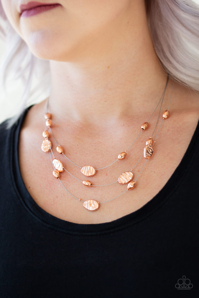 Featuring smooth and delicately hammered finishes, mismatched shiny copper beads are threaded along dainty silver wire, creating floating layers below the collar. Features an adjustable clasp closure.  Sold as one individual necklace. Includes one pair of matching earrings.