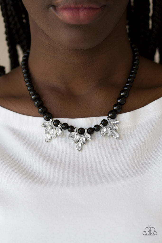 A strand of shiny black beads drapes elegantly below the collar. Featuring regal marquise style cuts, glittery white rhinestone frames swing from the beaded strand for a timeless finish. Features an adjustable clasp closure.  Sold as one individual necklace. Includes one pair of matching earrings.
