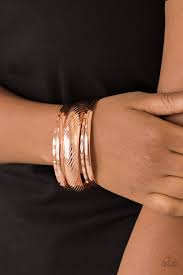 Featuring serrated and smooth surfaces, mismatched shiny copper bangles stack across the wrist for a casual look.  Sold as one set of four bracelets.