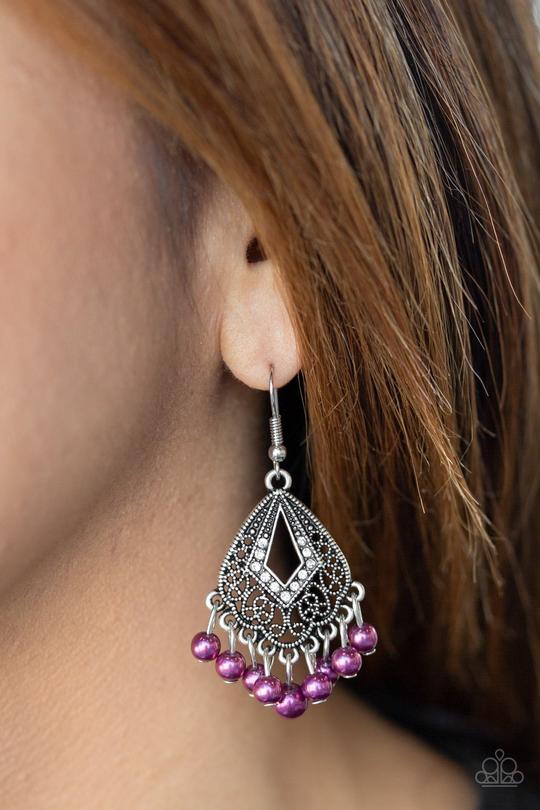 A pearly purple fringe swings from the bottom of an ornate silver frame radiating with glassy white rhinestones for a refined look. Earring attaches to a standard fishhook fitting.  Sold as one pair of earrings.