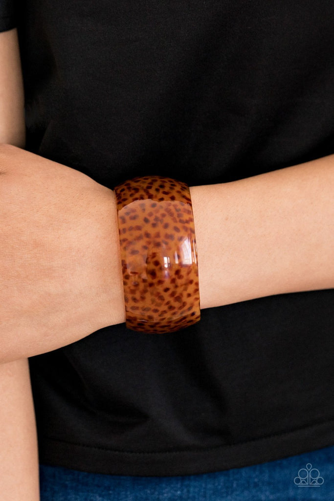A thick brown acrylic cuff curls around the wrist for a wildly retro fashion.  Sold as one individual bracelet.