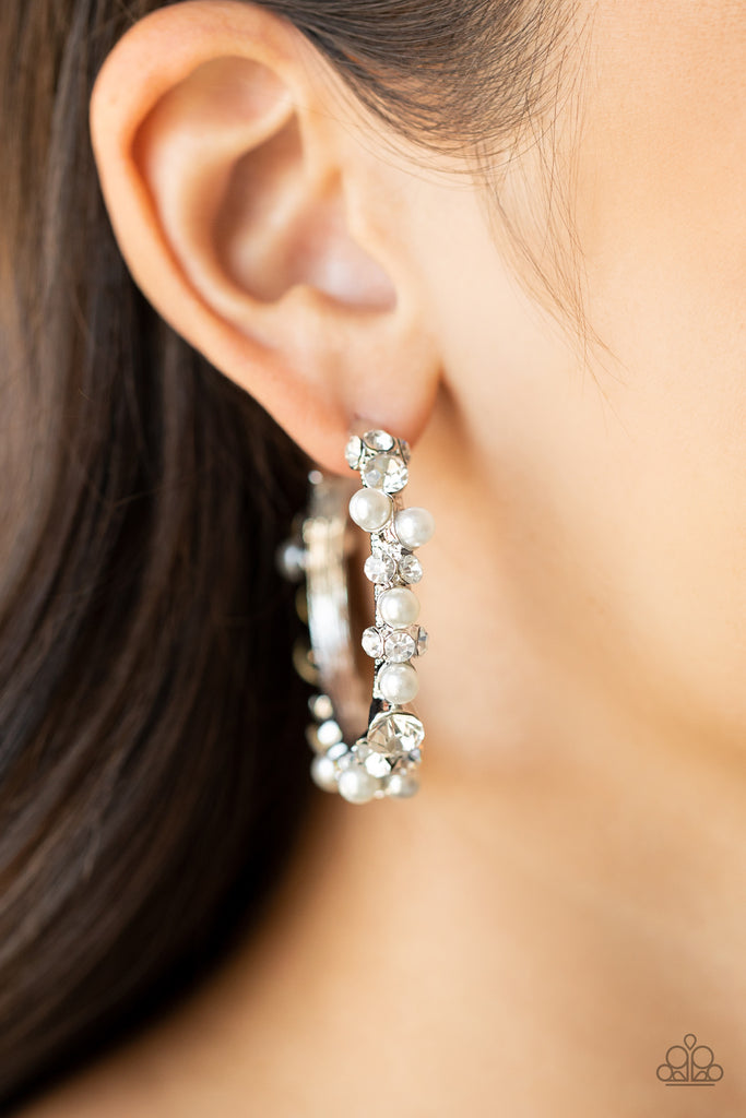 A bubbly array of classic white rhinestones and glassy white rhinestones are encrusted along the front of a silver hoop, creating an elegantly effervescent look. Earring attaches to a standard post fitting. Hoop measures approximately 1 1/2" in diameter.  Sold as one pair of hoop earrings.