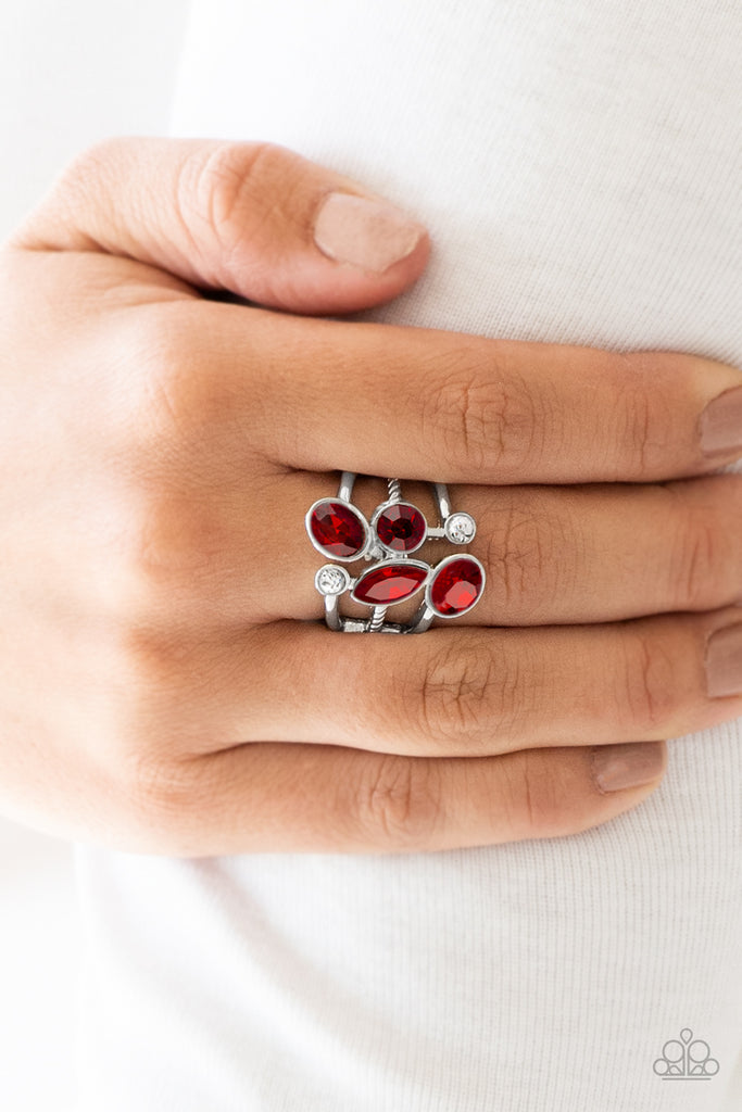 Varying in shape and cut, glassy white rhinestones and glittery red rhinestones tumble down the center of layered silver bands for an edgy look. Features a stretchy band for a flexible fit.  Sold as one individual ring.