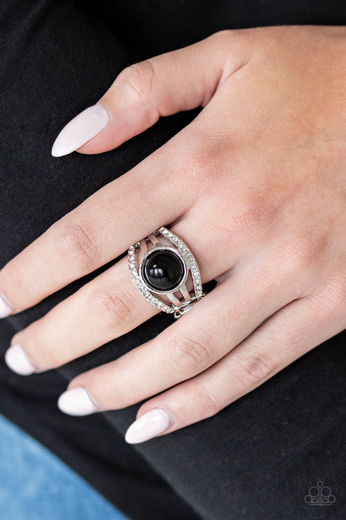 Radiating with glassy white rhinestones, row after row of glittering silver bars arc across the finger. A shiny black bead is pressed into the center of the layered bands, adding a dramatically refined finish to the piece. Features a stretchy band for a flexible fit.  Sold as one individual ring.