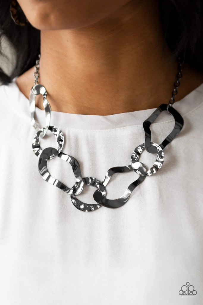 Brushed in a high-sheen finish, warped gunmetal links connect below the collar for an edgy statement. Features an adjustable clasp closure.  Sold as one individual necklace. Includes one pair of matching earrings.