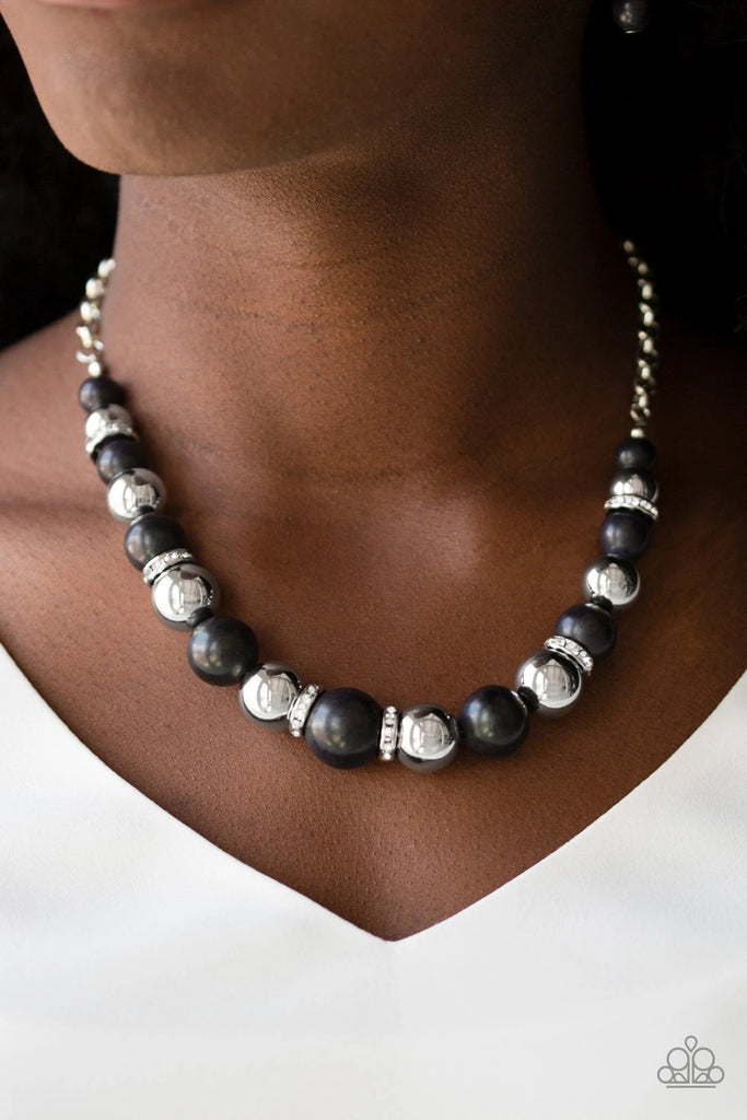 A collection of faux black stones, shiny silver beads, and white rhinestone encrusted rings join below the collar in a refined fashion. Features an adjustable clasp closure.  Sold as one individual necklace. Includes one pair of matching earrings.