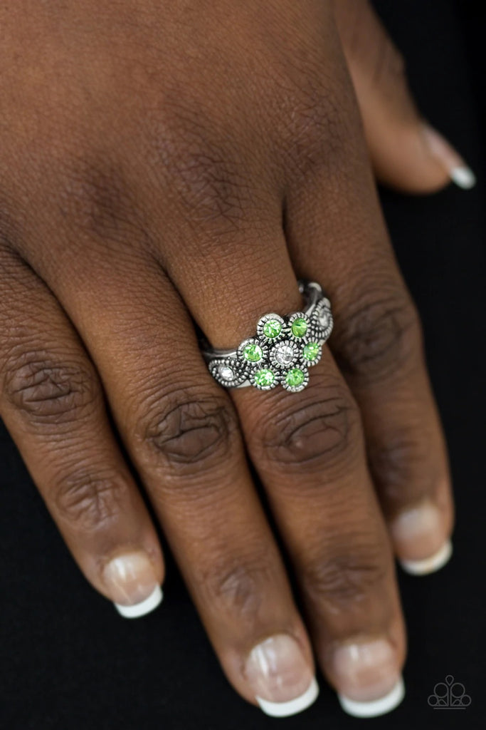 Glittery green rhinestones bloom from a white rhinestone center, creating a glamorous floral band. Features a dainty stretchy band for a flexible fit.  Sold as one individual ring.