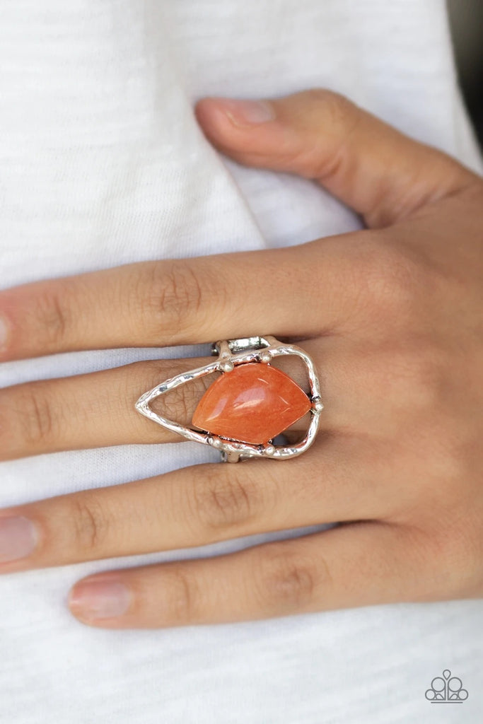 An abstract orange stone is nestled inside a hammered silver triangle, creating an artisan inspired frame atop the finger. Features a stretchy band for a flexible fit.  Sold as one individual ring.