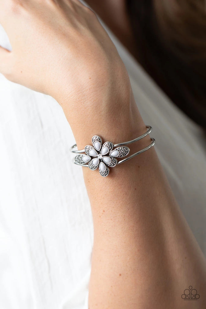 A collection of decorative silver petals topped with gray accents fans out around a dainty white rhinestone center, creating a whimsical floral frame that sits atop an airy silver cuff. Features a hinged closure.  Sold as one individual bracelet.