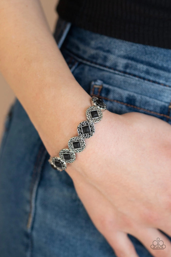 Featuring square black stone centers, ornate silver frames are threaded along a stretchy band around the wrist for a seasonal flair.  Sold as one individual bracelet.