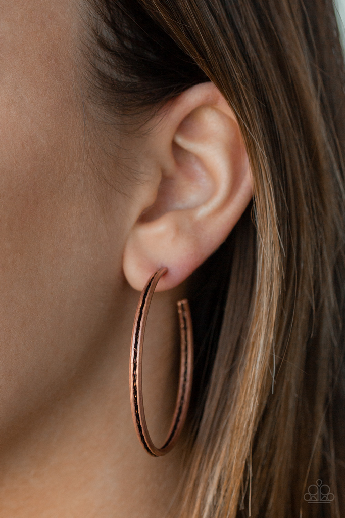 The inside and outside of a folded copper hoop is stamped in tribal inspired textures for a trendy look. Earring attaches to a standard post fitting. Hoop measure approximately 2" in diameter.  Sold as one pair of hoop earrings.