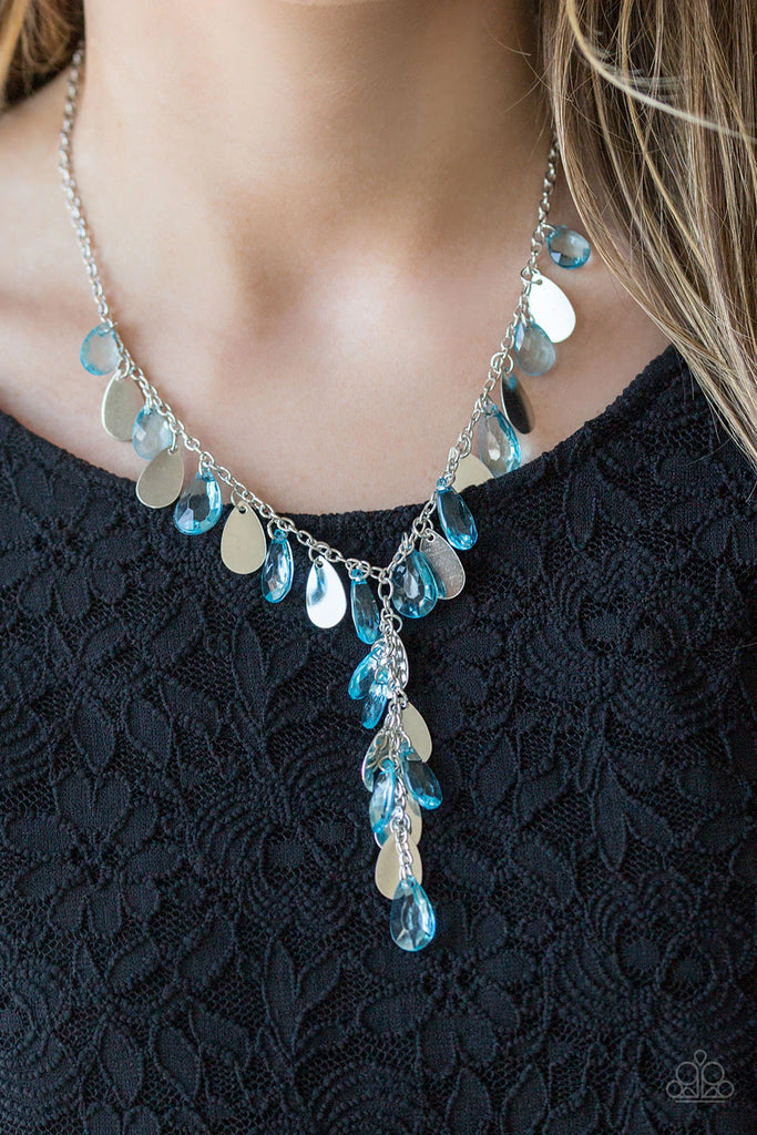 Flat silver teardrops and blue crystal-like teardrops swing from the bottom of a shimmery silver chain below the collar. A matching tassel swings from the center, creating a whimsical extended pendant. Features an adjustable clasp closure.  Sold as one individual necklace. Includes one pair of matching earrings.