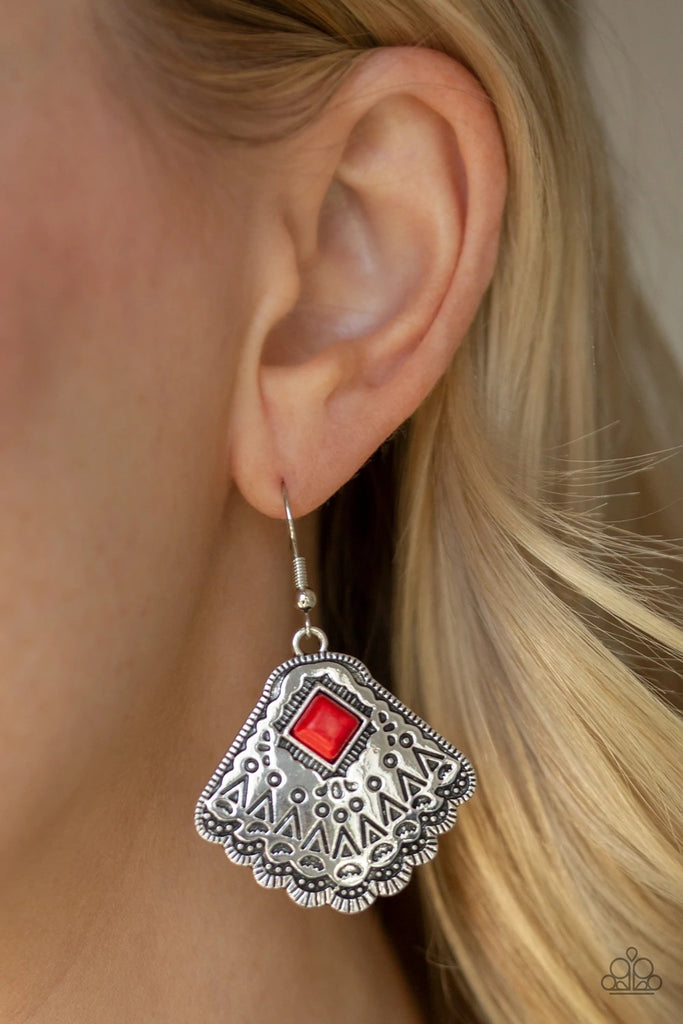 Stamped in tribal inspired patterns, a shimmery silver frames fan out from the bottom of a square fiery red stone for a seasonal flair. Earring attaches to a standard fishhook fitting.  Sold as one pair of earrings.