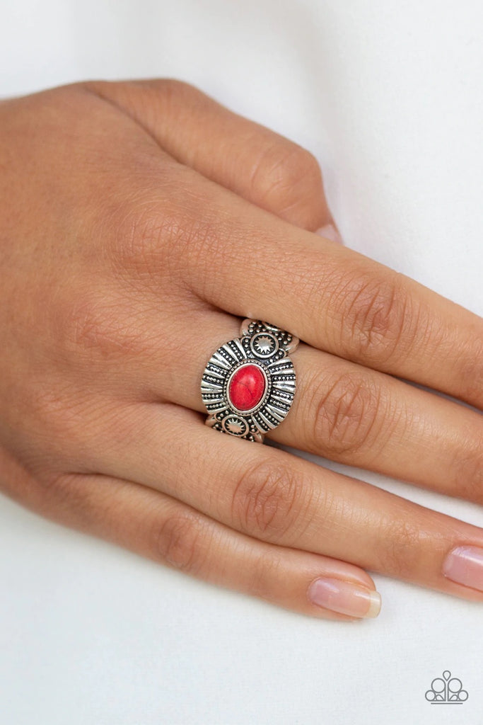 An oval red stone is pressed into the center of an ornate silver frame radiating with linear and sunburst patterns for a seasonal flair. Features a dainty stretchy band for a flexible fit.  Sold as one individual ring.