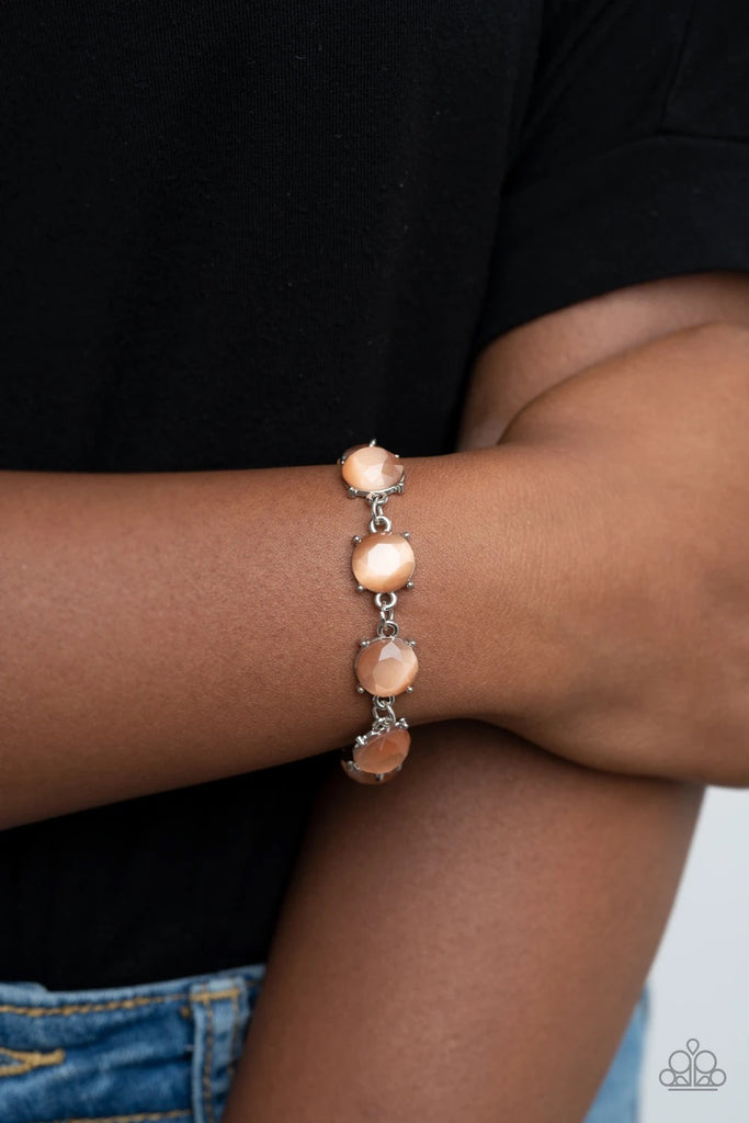 A glowing collection of faceted orange cat's eye stone frames delicately connect across the wrist for an ethereal look. Features an adjustable clasp closure.  Sold as one individual bracelet.  