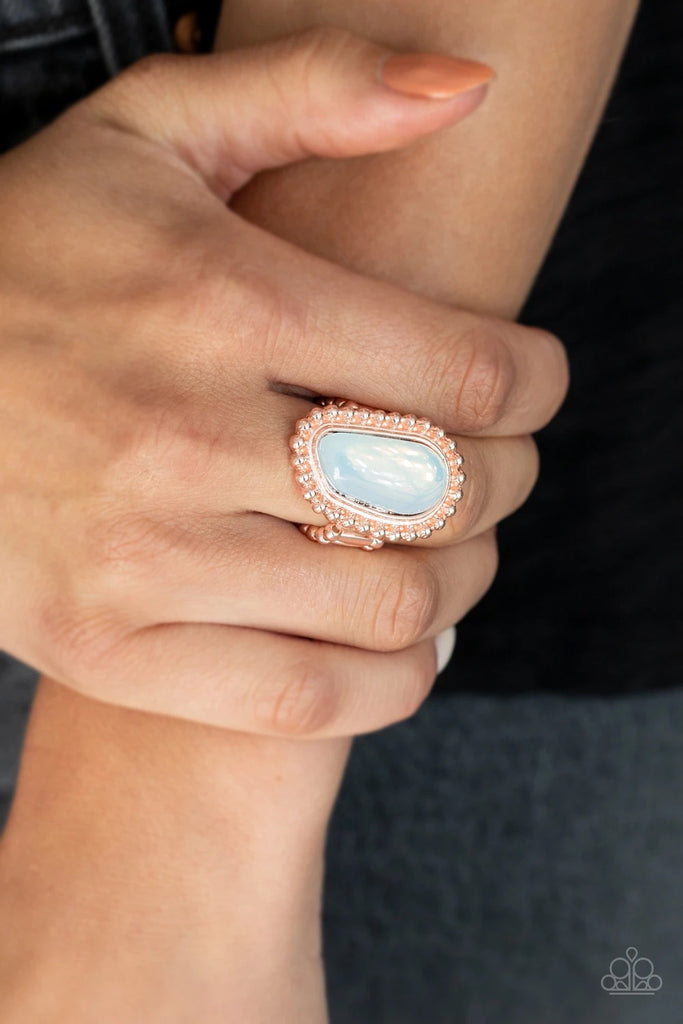 An asymmetrical opalescent stone is pressed into the center of a studded rose gold frame, creating an ethereal centerpiece atop the finger. Features a stretchy band for a flexible fit.  Sold as one individual ring.