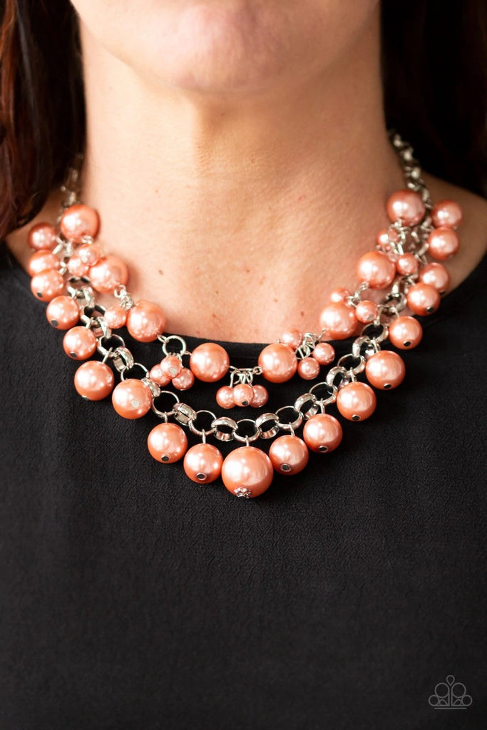 Two rows of mismatched coral pearls gorgeously drape below the collar. Featuring oversized silver links and an assortment of pearl sizes, the bubbly strands layer into a dramatic fringe for a modern timelessness. Features an adjustable clasp closure.  Sold as one individual necklace. Includes one pair of matching earrings.