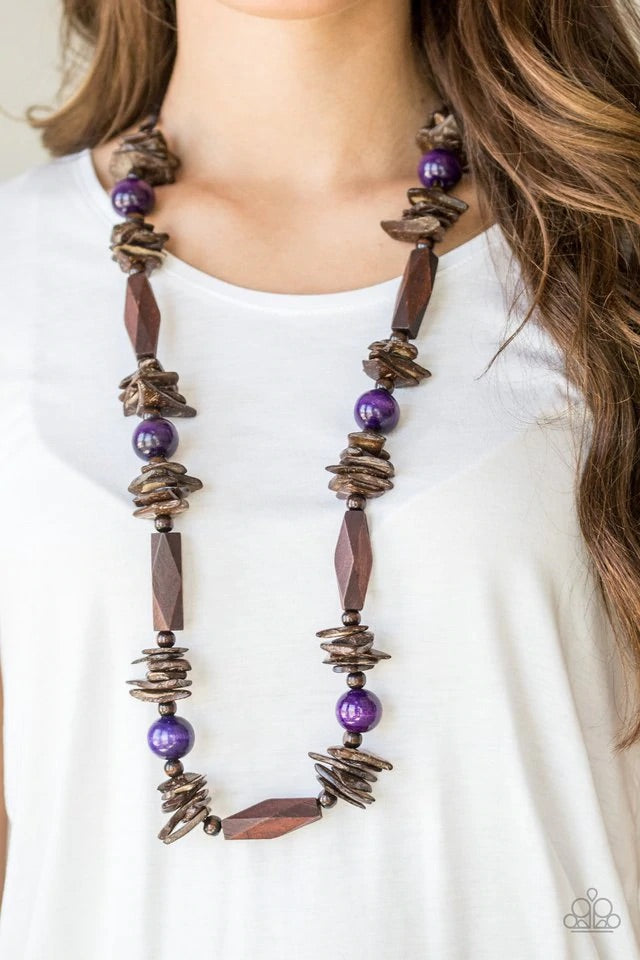 Featuring round, faceted, and distressed finishes, mismatched brown wooden beads are threaded along shiny brown cording. Vivacious purple wooden beads trickle between the earthy accents, adding a colorful finish to the summery palette. Features an adjustable sliding knot closure. Sold as one individual necklace. Includes one pair of matching earrings.