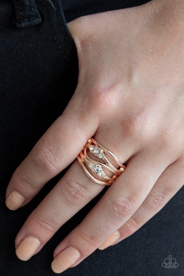 Trios of glittery white rhinestones are encrusted along wavy rose gold bands, creating refined layers. Features a stretchy band for a flexible fit.  Sold as one individual ring.