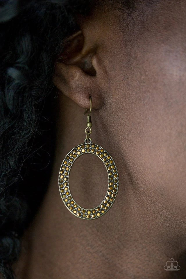Encrusted in two rows of glassy aurum rhinestones, a shimmery brass hoop swings from the ear in a glamourous fashion. Earring attaches to a standard fishhook fitting. Sold as one pair of earrings.