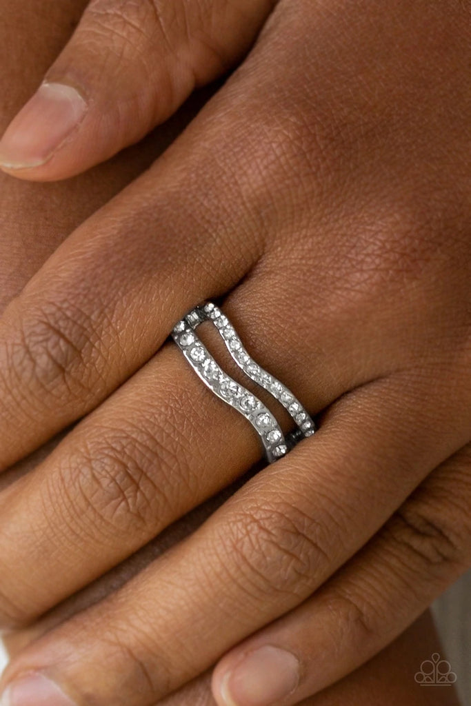 Varying in size, glittery white rhinestones are encrusted along waving silver bands for a refined look. Features a dainty stretchy band for a flexible fit.  Sold as one individual ring.