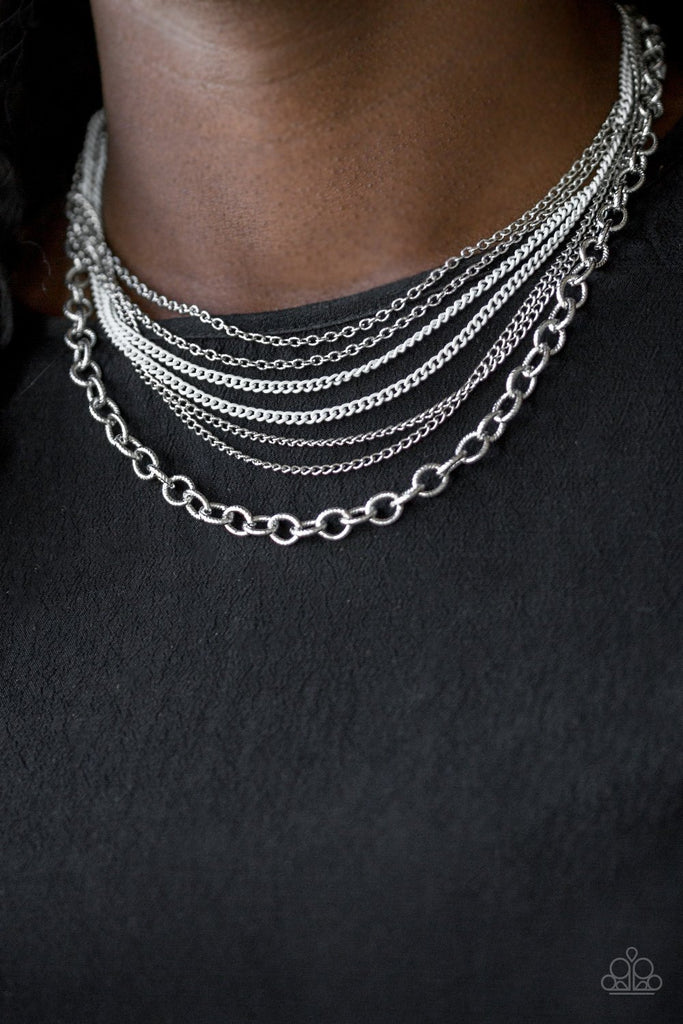 Painted in a neutral finish, shiny white chains join a collision of silver chains below the collar for a daring industrial look. Features an adjustable clasp closure.  Sold as one individual necklace. Includes one pair of matching earrings.