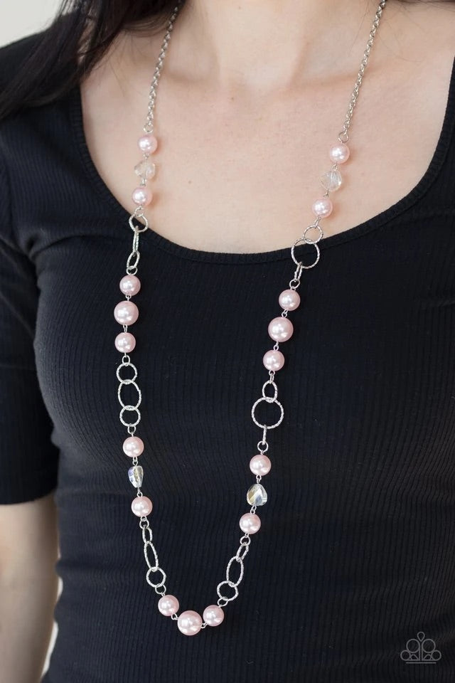 A refined collection of glassy white gems, textured silver rings, and pearly pink beads drape across the chest for a timeless look. Features an adjustable clasp closure. Sold as one individual necklace. Includes one pair of matching earrings.